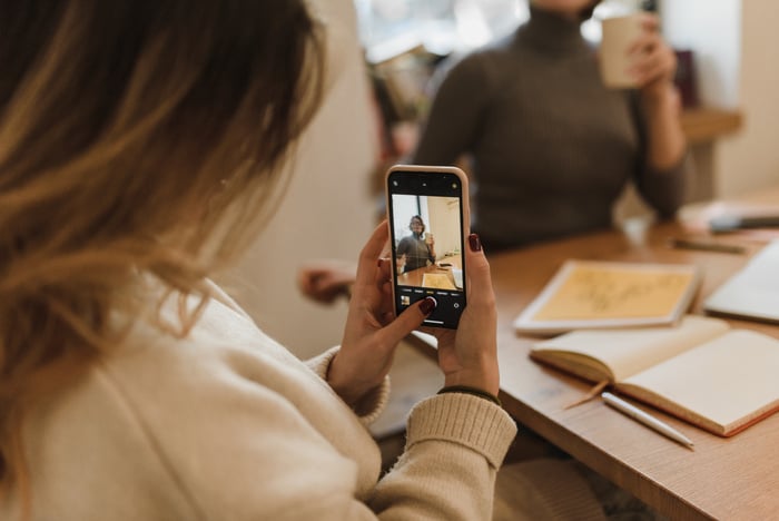 Woman in White Sweater Holding Iphone 6